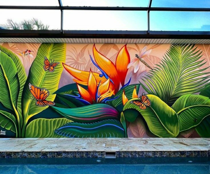 a mural on the side of a building next to a swimming pool with butterflies and flowers painted on it