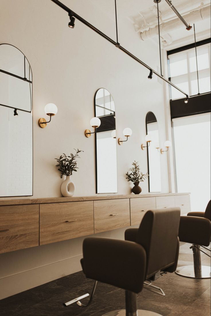 a hair salon with chairs and mirrors on the wall