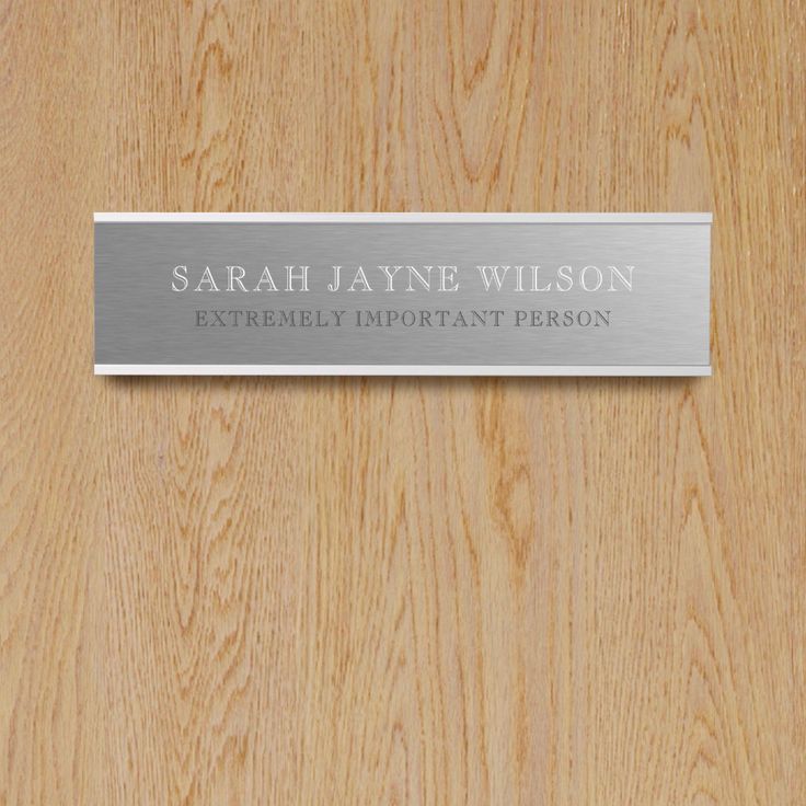 a wooden door with a metal name plate on it