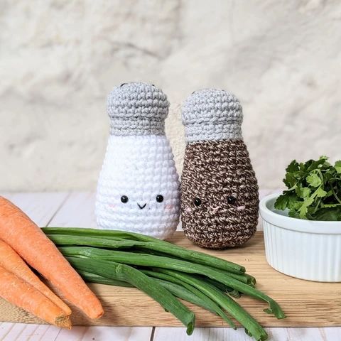 crocheted carrots and green beans on a cutting board next to some vegetables