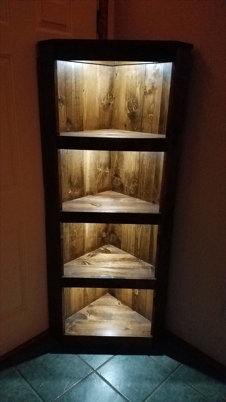 an empty shelf in the corner of a room with tile flooring and wooden walls