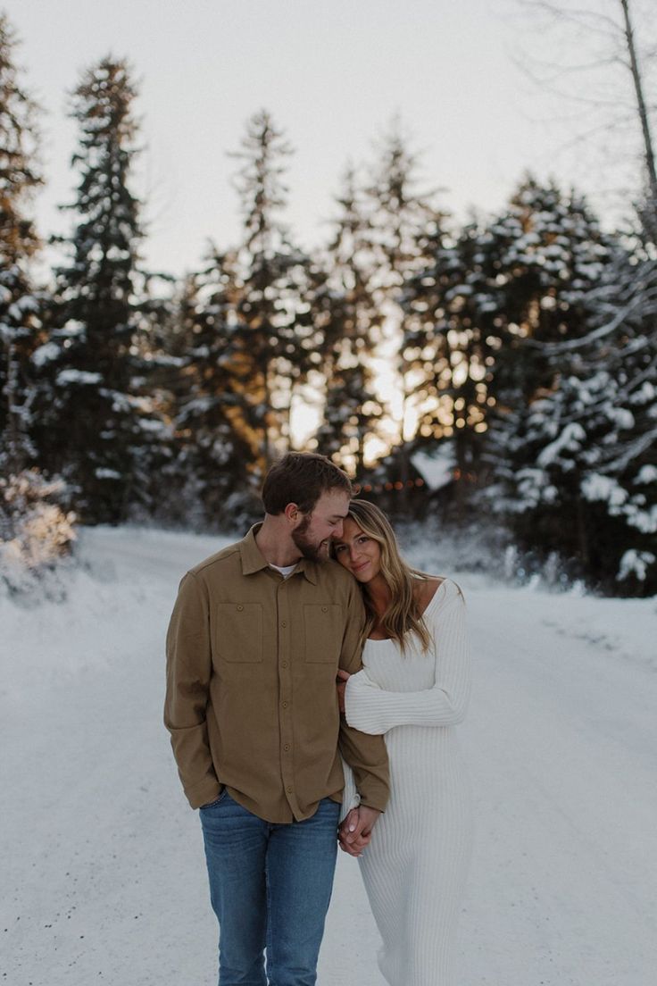 a man and woman are standing in the snow