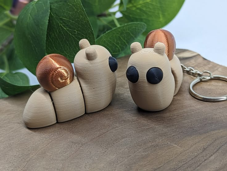 three wooden toy animals sitting next to each other on top of a piece of wood