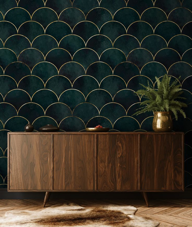 a sideboard with a potted plant on it in front of a green wall