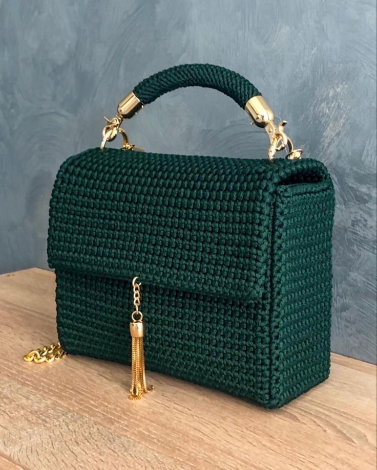 a green handbag sitting on top of a wooden table