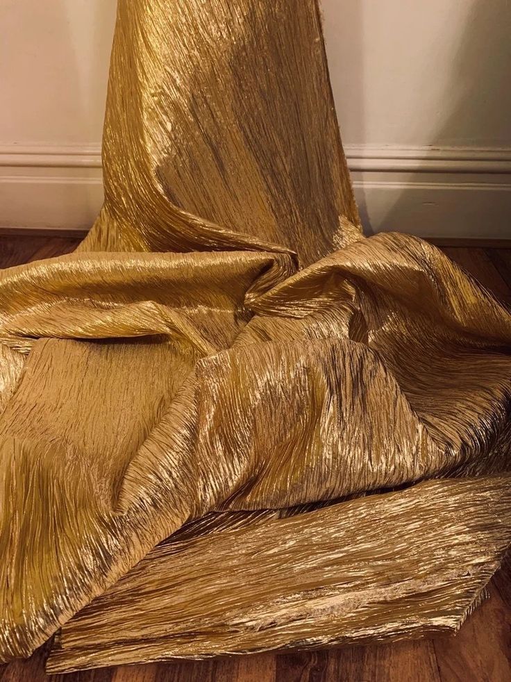 a gold cloth draped on top of a wooden floor