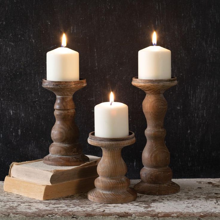 three candles sitting on top of a wooden stand