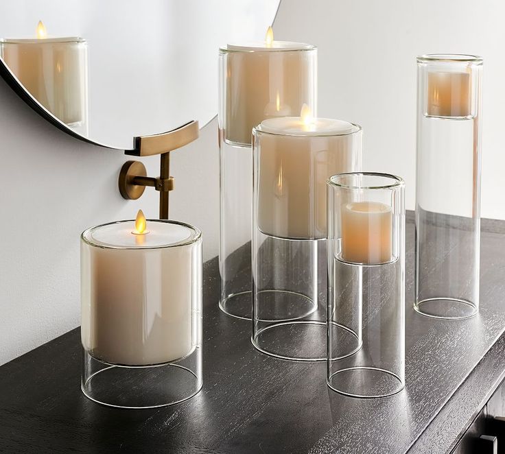 three candles are sitting in front of a mirror