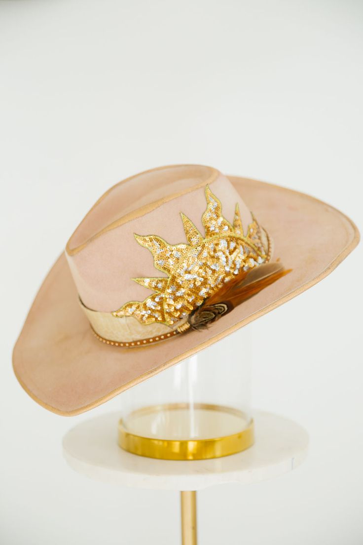 SUNLIGHT SEQUIN RANCHER is a classic rancher hat with a unique twist. It features a sequin sun patch, a stylish snakeskin band, and stunning gold glitter accents. This one of a kind hat adds a touch of glamour to your outfit. This hat is ONE OF A KIND, created by our owner Stephanie. To receive item quicker, expedited shipping is available at checkout. Art Hats, Rancher Hat, Gold Glitter, Snake Skin, Sequin, Twist, Glitter, Sun, Band