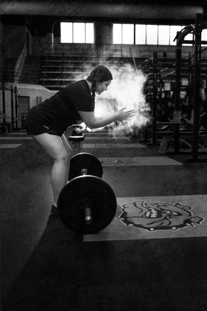 a woman squatting down while holding a barbell