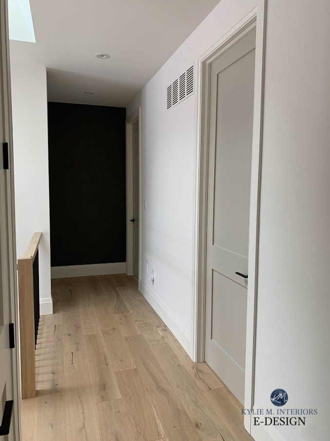 an empty room with white walls and wood floors is seen in this image from the hallway