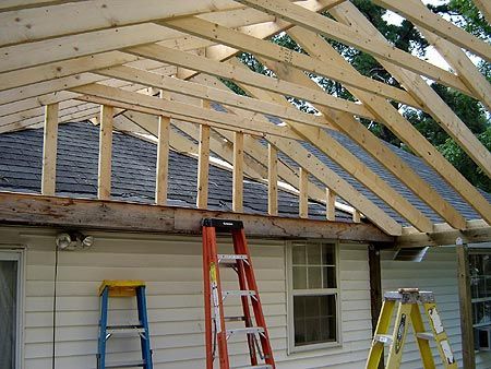 two ladders are on the roof of a house