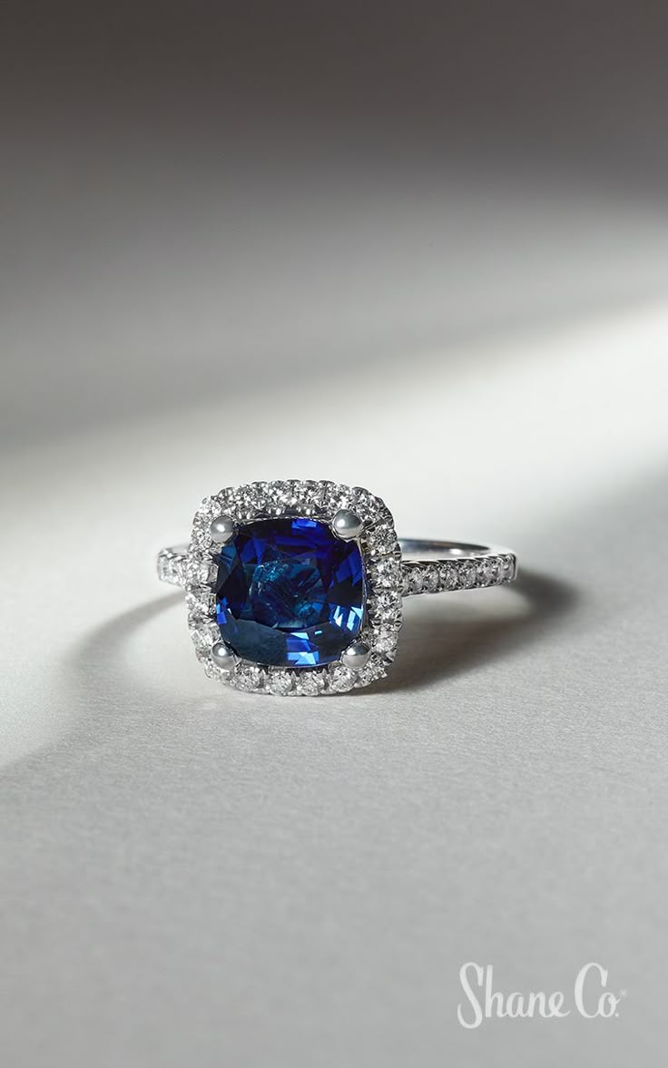 a blue and white ring with diamonds on it's sides, sitting on a table