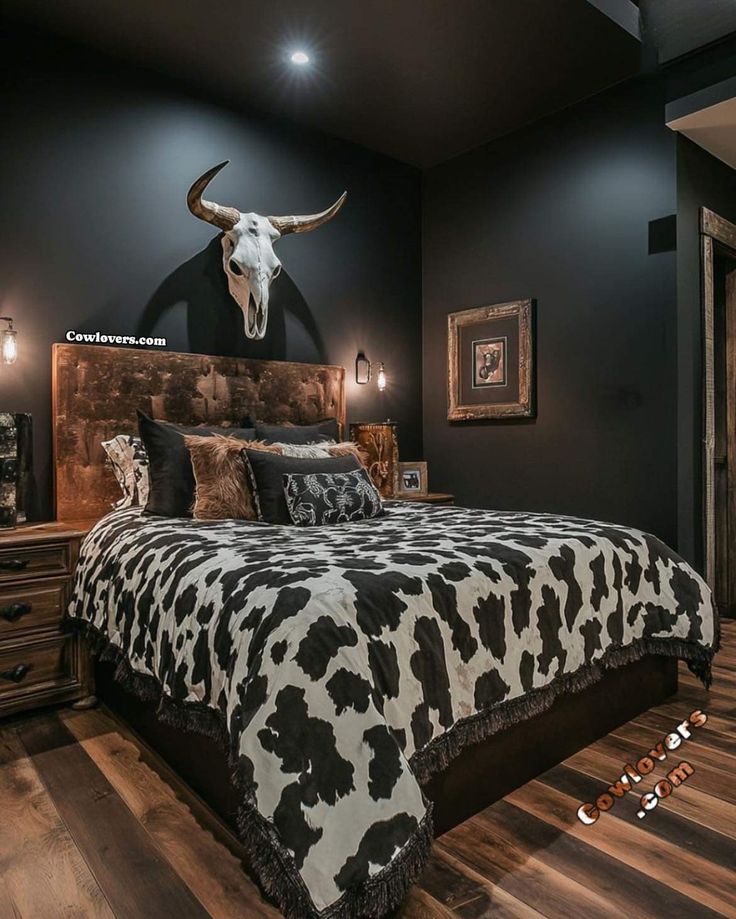 a cow skull mounted on the wall above a bed in a room with wood floors