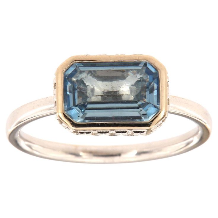 This 14k White gold delicate ring features a 1.23 Carat Blue Aquamarine emerald cut bezel set East-West style. Sixteen (16)Brilliant round diamonds are micro-prong set in a hidden halo on the crown to create the sparkle look every woman is looking to have. The diamond weight is 0.23 Carat, The band is 2 mm wide, and the ring size is 6.5 and resizable per request. Blue Emerald Cut Ring With Bezel Setting, Blue Emerald Cut Rings With Bezel Setting, Emerald-cut Topaz Ring In 14k White Gold, Emerald Cut Topaz Ring In 14k White Gold, Blue Emerald Ring With Bezel Setting, Formal Bezel-set Baguette-cut Emerald Ring, Luxury Emerald Cut Sapphire Solitaire Ring, Emerald-cut Yellow Gold Topaz Ring With Bezel Setting, Formal Baguette Cut Emerald Ring With Bezel Setting