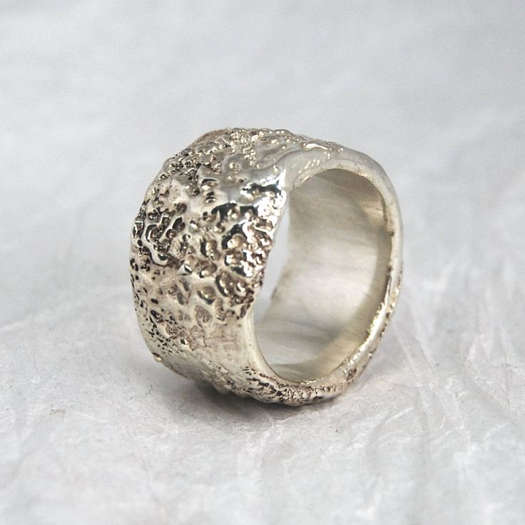 a silver ring sitting on top of a white surface