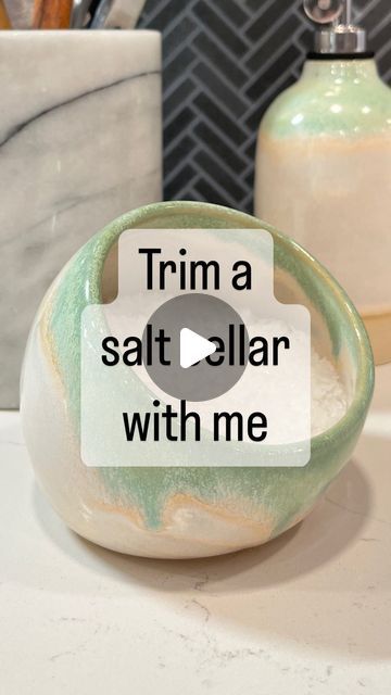 a green and white bowl sitting on top of a counter next to a soap dispenser