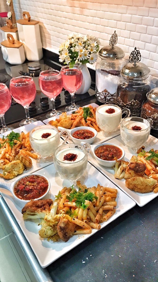 a table topped with lots of different types of food and glasses of wine next to each other