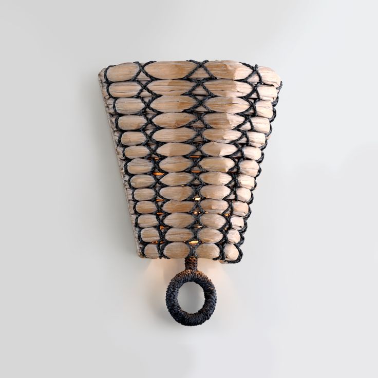 a wall light made out of wood and rope with a ring hanging from it's side