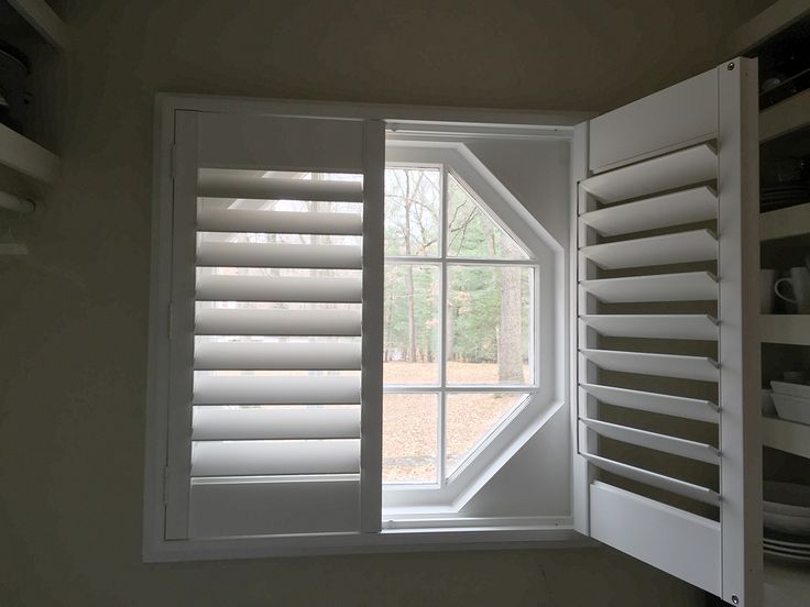 an open window with shutters on both sides