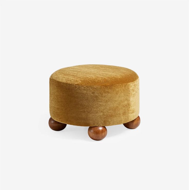 a small round ottoman with wooden wheels on the bottom and an upholstered foot rest