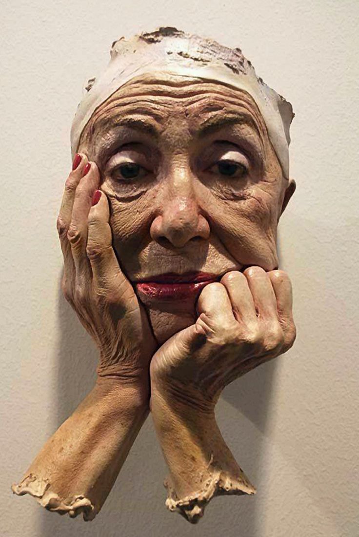 an old woman's face with hands on her face