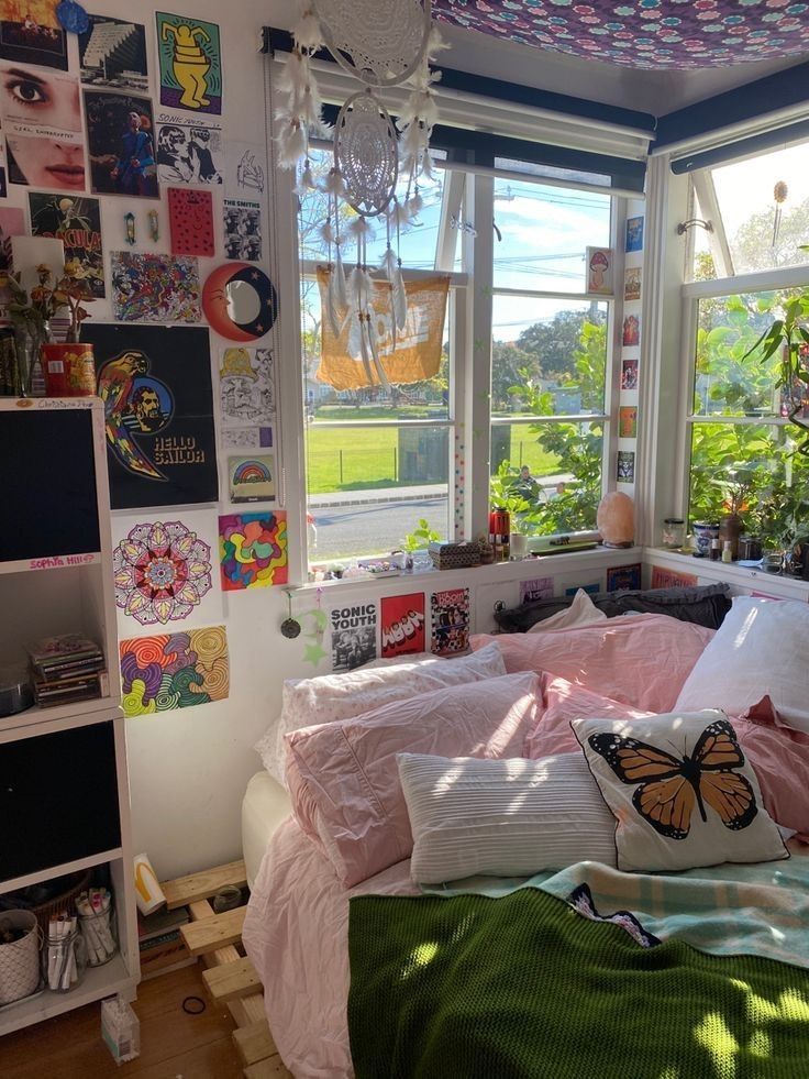 a bedroom with lots of pictures on the walls and ceiling, along with a bed covered in pink sheets