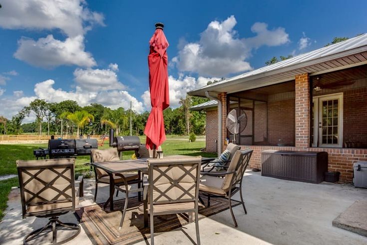 an outdoor patio with table, chairs and umbrella