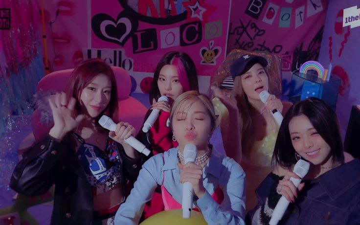 girls singing into microphones in front of a pink wall