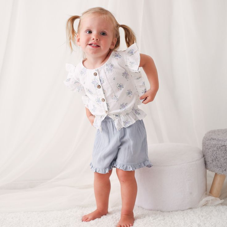 Get ready for some summer fun with the Aliya Skye Short and Top set! These super soft cotton shorts feature an elastic waist for ultimate comfort, while the top boasts flutter sleeves and buttons down the front. Perfect for any little girl, this outfit is sure to become her go-to choice. Wash cold with like colors Lay flat to dry; Minor shrinkage likely if tumble dried 100% cotton Playful Short Tops For Spring, Summer Playwear Tops With Elastic Waistband, Cotton Tops With Elastic Waistband For Playwear, Casual Tops With Elastic Waistband For Play, Playful Spring Short Set, Cute Short Tops For Playtime, Cute Short Set For Spring Playwear, Spring Short Set For Playwear, Cute Summer Bottoms For Playdate