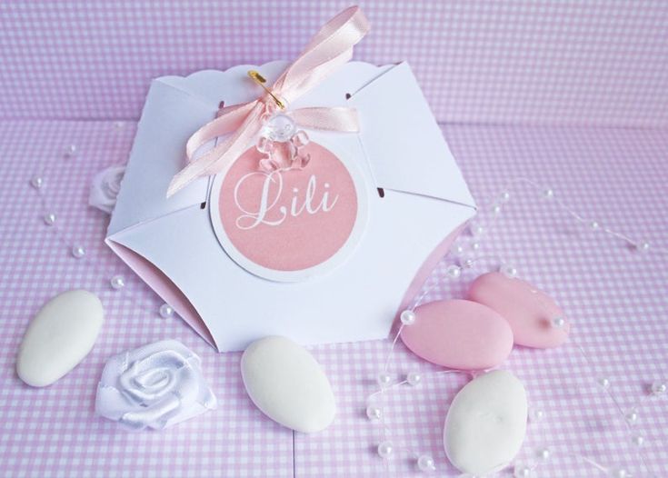 a pink and white treat box with cookies on the table next to it that says lil