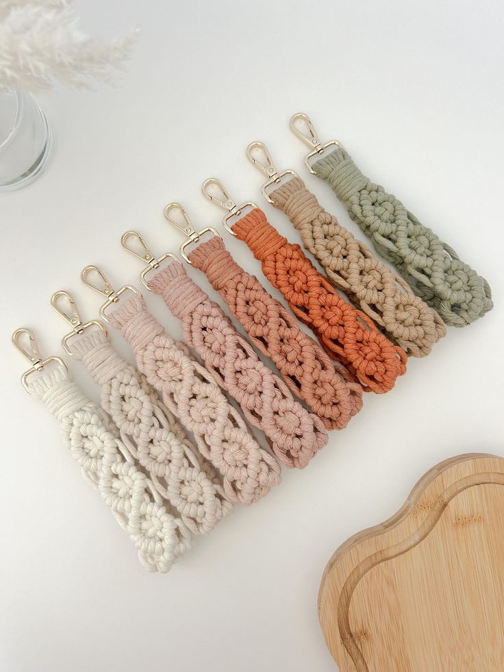 there are many crocheted items hanging from hooks on the wall next to a cutting board