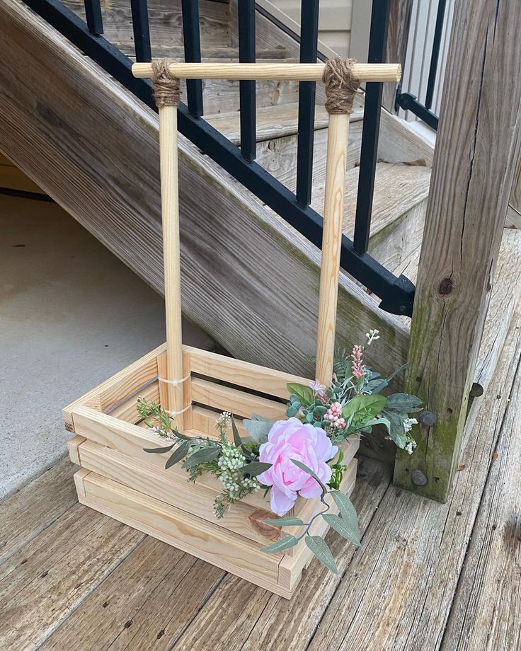 a wooden crate with flowers in it sitting on the steps