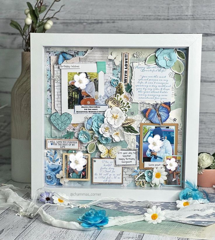 a white frame filled with pictures and flowers on top of a wooden table next to a potted plant