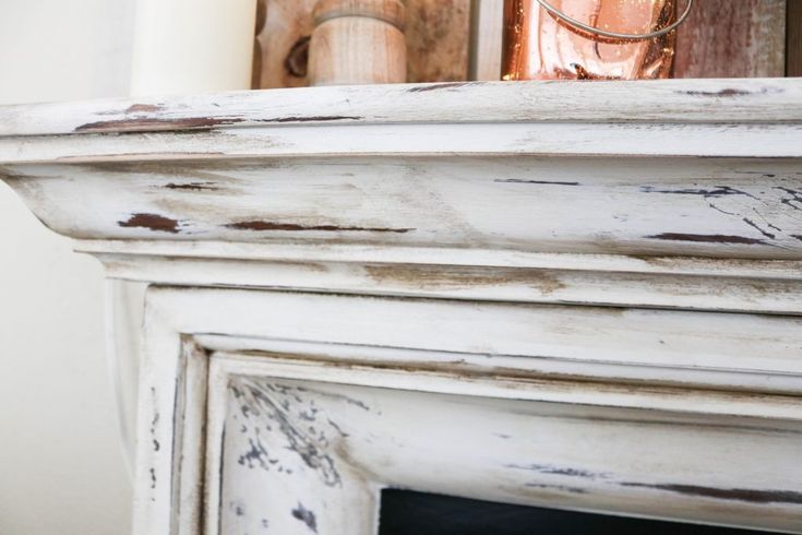 an old white fireplace with rusted paint on it