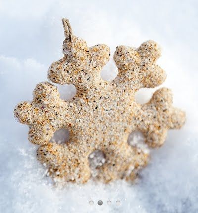 a snowflake made out of sand sitting on top of the snow covered ground