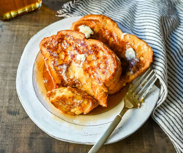 two pieces of french toast on a plate with a fork