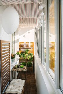 the balcony is lined with plants and potted plants, along with an outdoor bench