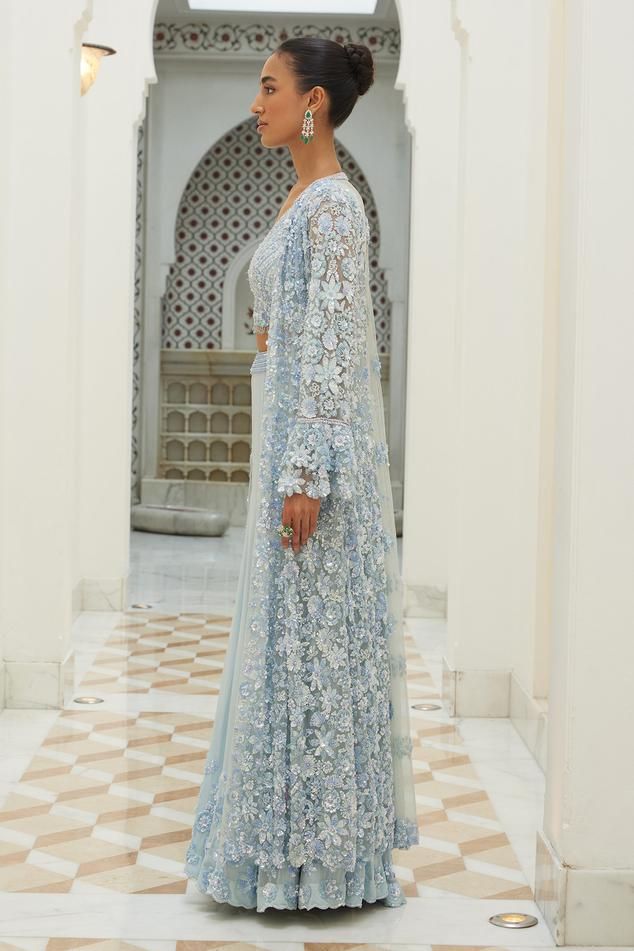 Ice blue longline jacket embroidered in tonal and silver beads, sequins and crystals and bell sleeves. Paired with a padded embroidered bustier and sharara.
Components: 3
Pattern: Embroidered
Type Of Work: Sequin, Bead, Crystal
Neckline: V Neck
Sleeve Type: Bell
Fabric: Net, Georgette
Color: Blue
Occasion: Wedding, Mehendi and Haldi - Aza Fashions Blue Palazzo Set With Chikankari Embroidery For Reception, Blue Chikankari Embroidery Palazzo Set For Reception, Designer Front Open Lehenga With Intricate Embroidery, Blue Chikankari Embroidered Sharara For Reception, Long Sleeve Lehenga With Chikankari Embroidery, Blue Palazzo Set With Intricate Embroidery And Long Sleeves, Blue Palazzo Set With Intricate Embroidery, Blue Long Sleeve Palazzo Set With Intricate Embroidery, Long Sleeve Choli With Chikankari Embroidery For Reception