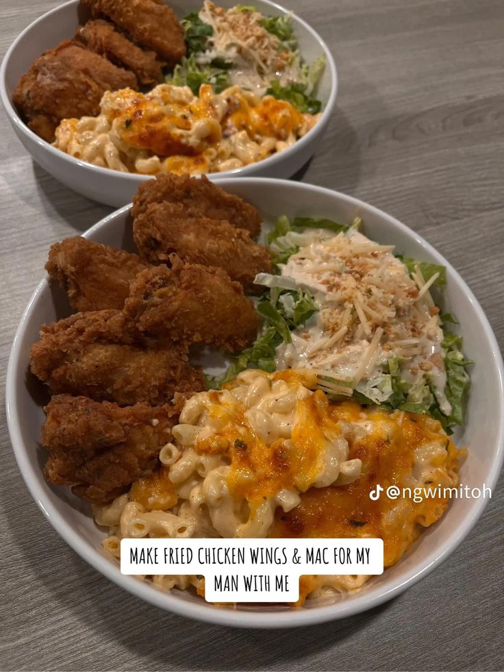 two white bowls filled with chicken wings, macaroni and cheese next to salad