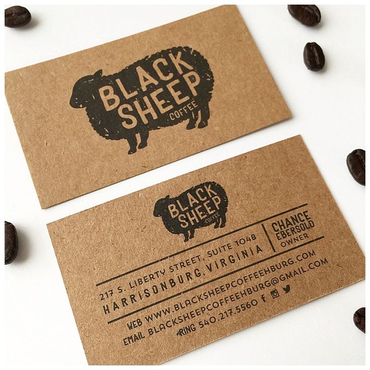 two brown business cards with black sheep logo on them and coffee beans scattered around it