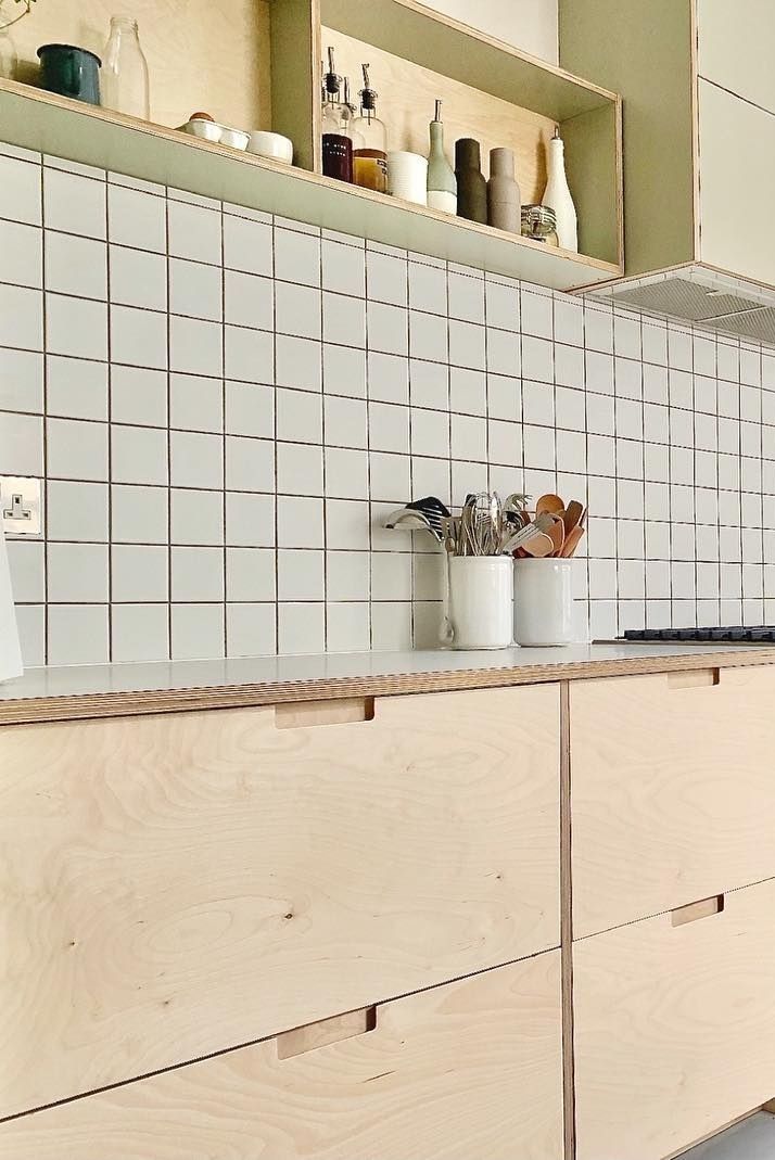 a kitchen with wooden cabinets and white tile backsplashing on the counter top