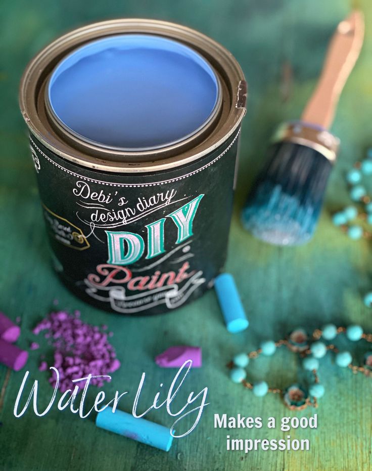 a blue paint can sitting on top of a table next to beads and a brush