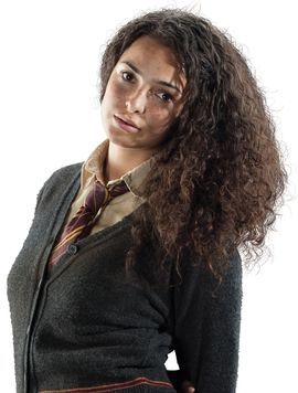 a woman with long hair wearing a harry potter shirt, tie and cardigan sweater