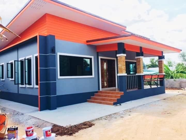 a blue house with orange trim on the roof