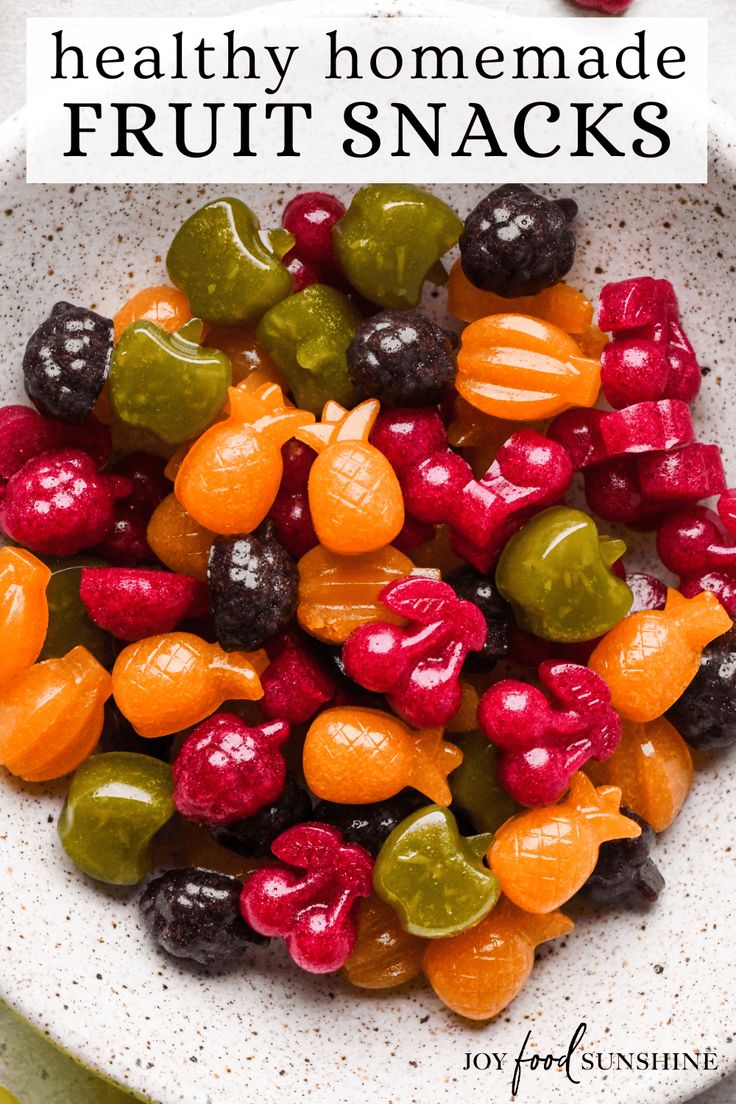 a white bowl filled with fruit snacks on top of a table