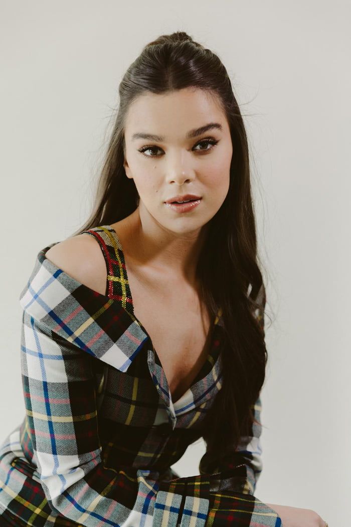 a woman with long dark hair wearing a plaid shirt