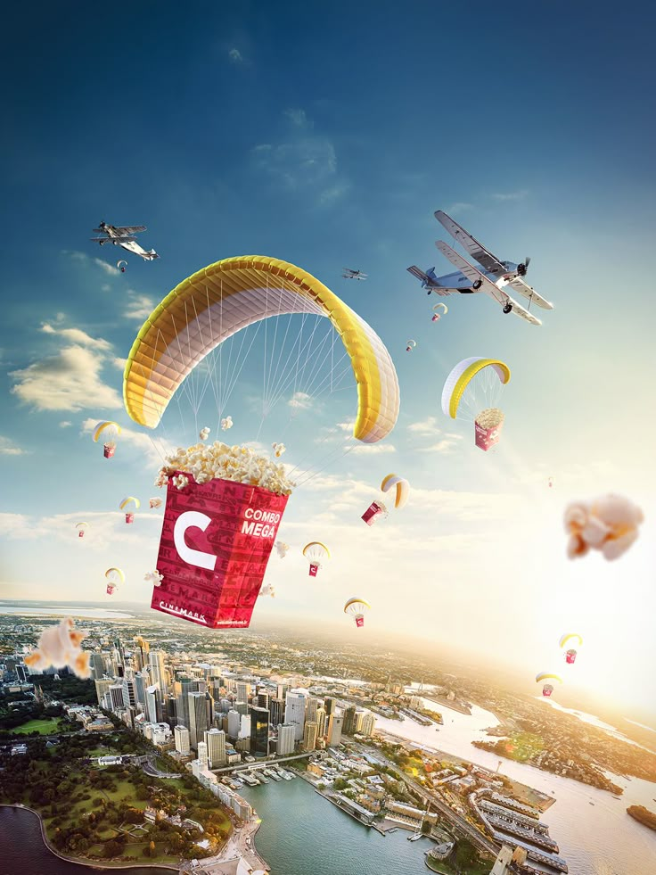 an aerial view of a city with many kites flying over the water and buildings