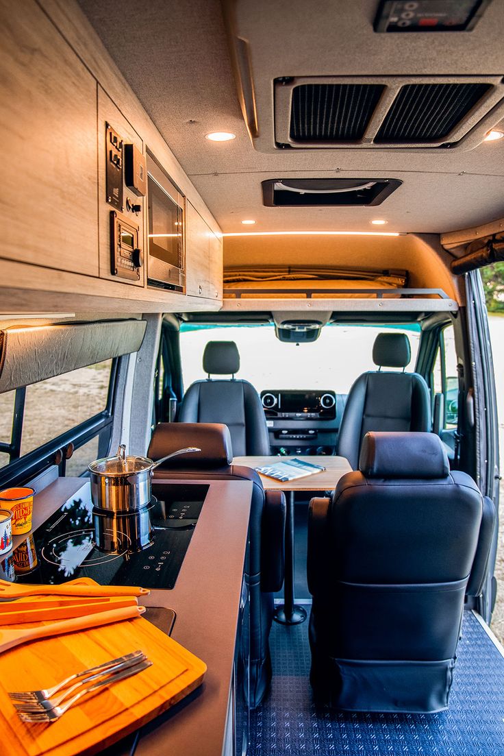 an interior view of a camper van with the kitchen and dining area in place