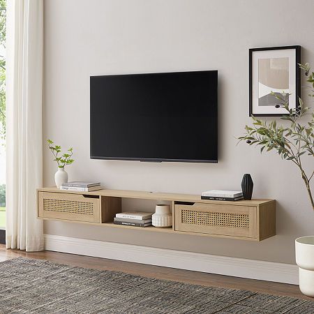 a flat screen tv mounted to the side of a wall next to a potted plant